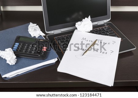 Desk with calculator, computer, paper and pen for doing income taxes
