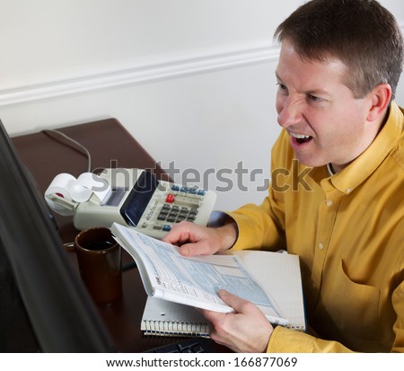 Photo of mature man, looking at data on computer monitor, working on taxes while going into a total rage of anger with office equipment in background