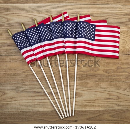 Overhead view of United States of America Flags positioned on rustic wooden boards.