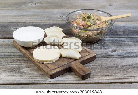 Horizontal photo of homemade traditional Chinese Dumplings being made from raw ingredients