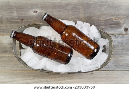 Overhead view of bottled beer in bucket of fresh real ice with dew on the outside