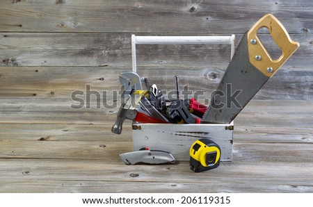 Horizontal view of an old tool holder containing basic home repair tools on rustic wooden boards