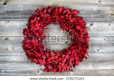 Top view of horizontal image of autumn wreath made with real tree leaves on rustic wooden boards