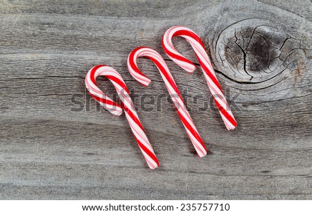 Top view close up of three candy canes placed on rustic wood