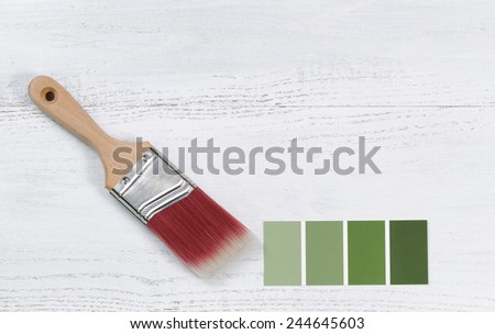 New paint brush and paint color choice template on white wooden boards with plenty of copy space