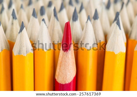 Close up front image of stacked pencils with focus on tip of red pencil in middle of the stack