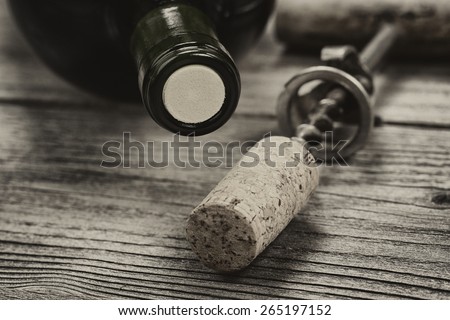Close up shot of top of wine bottle cork with antique opener in background in vintage style. Layout in horizontal format.