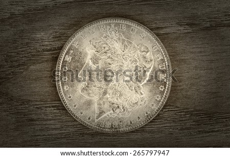 Vintage concept of a Silver Dollar in very good condition on aged wood. Slight vignette border around coin.