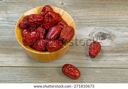 Image of dried dates in bowl on rustic wood. Layout in horizontal format.