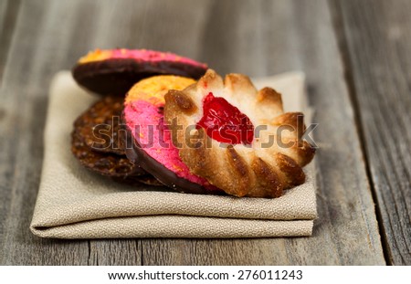 Close up image of assorted cookies resting in cloth napkin with rustic wood in background