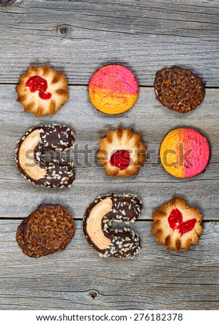 Top view angled shot of assorted cookies resting on rustic wood. Layout in vertical format.
