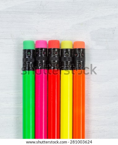 Close up of colorful pencil tip erasers on white desktop. Layout in vertical format.