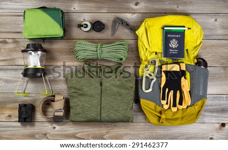 High angled view of organized hiking gear for climbing placed on rustic wooden boards.