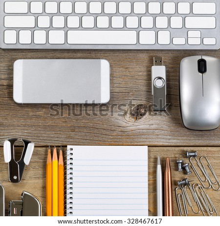 Office setting with keyboard and work supplies on rustic wooden desk