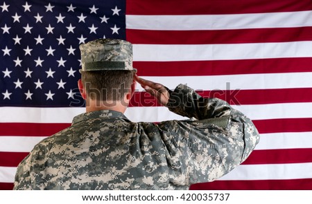 Male Veteran soldier, back to camera, saluting United States of America flag.