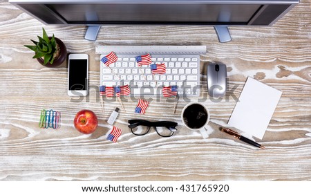 Top View office desktop with USA flags on rustic white wood. Fourth of July holiday concept.