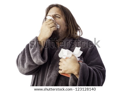 isolated sick man bundled up in a robe sneezing into a tissue