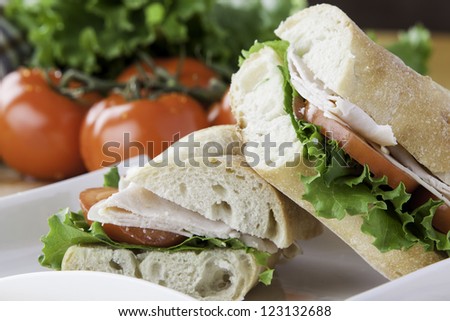 close up of a cut turkey sub with tomato, lettuce and cheese