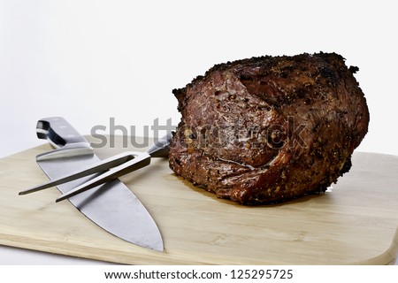 Prime Rib Roast sitting on a cutting board with a chef knife and carving fork