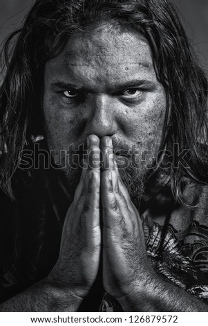 grungy, gritty looking closeup of white male praying in black and white