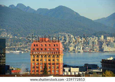 Historic Second Empire style Dominion Building and North Vancouver city skyline across Vancouver Harbour, Vancouver, British Columbia, Canada.