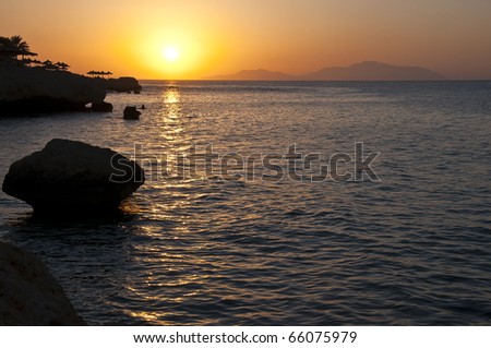 The shining sun rises because of horizon of the red sea