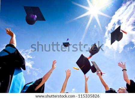 Students with congratulations throwing graduation hats in the air celebrating