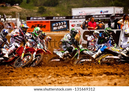 SI RACHA, THAILAND - MAR. 10 : Group of motocross riders at first curve during MX1 grandprix race 1 of The FIM Motocross World Championship Grandprix of Thailand, on March 10, 2013. Thailand.