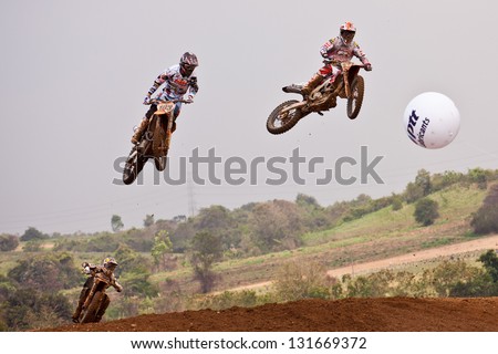 SI RACHA, THAILAND - MAR. 10 : 3 of motocross riders jump over the hill during MX1/2 of The FIM Motocross World C hampionship Grandprix of Thailand, on March 10, 2013. Thailand.