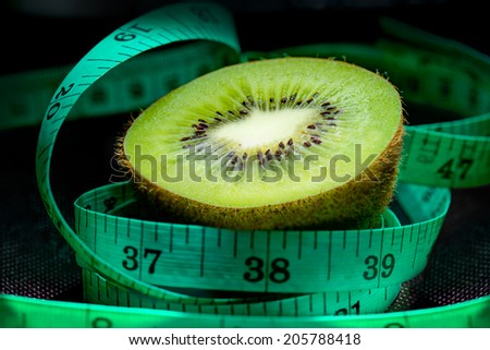 Closed up of Kiwi fruit and meter tape in low key light