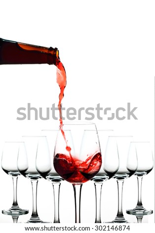 Red wine being in glasses isolated on white background. Splashing stop motion.