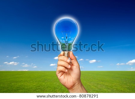 Ecological concept, reflection of nature in lamp with hand.