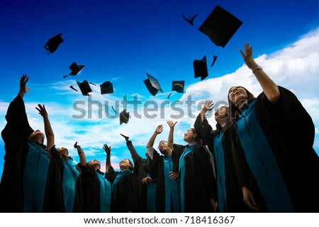 Group of graduates with congratulations throwing graduation hats in the air celebrating.