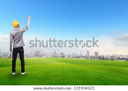 Engineer drawing, on green grass field with Building background