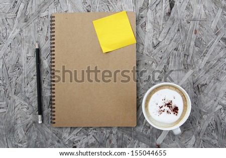 Cup of coffee and notepad on a wooden table