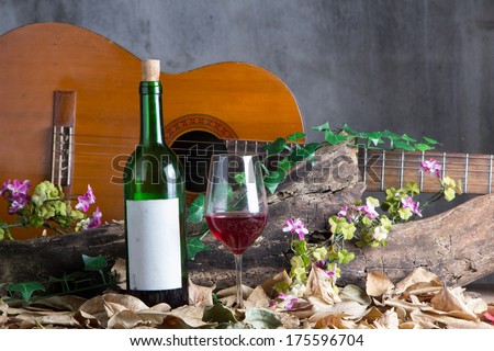 Red wine bottle and wine glass with acoustic guitar, Still life photography