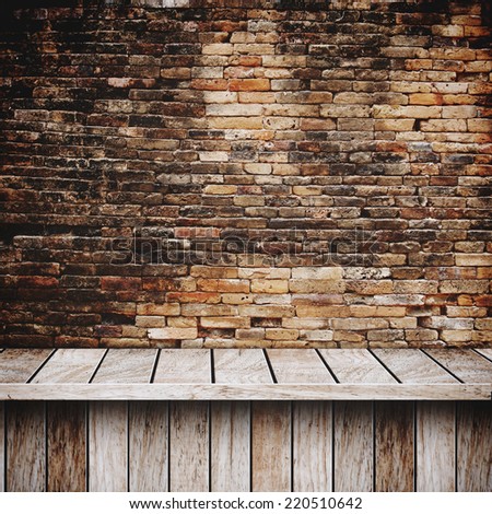 Wooden table in front of brick wall texture background, Grunge industrial interior Uneven diffuse lighting version design component