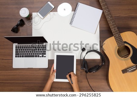 Office desk background, Hand written touchscreen on tablet PC with acoustic guitar, headphones recording scene project ideas concept. mobile phones, laptop computer, View from above with copy space
