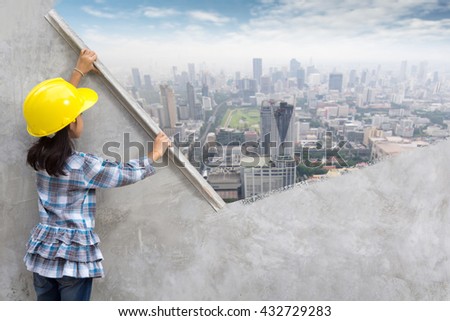 Little girl engineering ideas concept with hand holding plastering tools renovating a house. With painting modern city skyline, city street, cityscape, landscape, building,  skyscraper on wall
