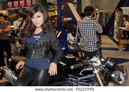 BANGKOK - DECEMBER 4: Female and male presenters model at the Triumph Motorcycle Booth on display at the 28th Thailand International Motor Expo on December 4, 2011 in Bangkok, Thailand.