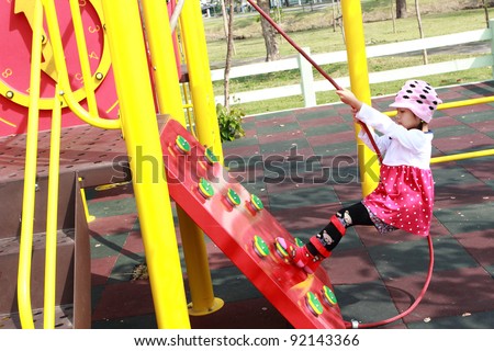 Asian Child girl jungle gym in playground. Outdoor park