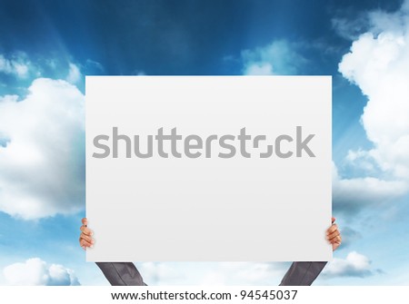 hand holding blank Poster on blue sky background