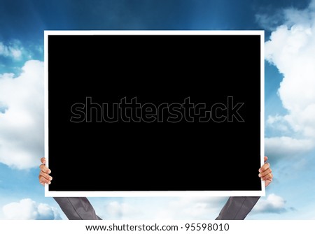 hand holding blank big framework for a photo on blue sky background