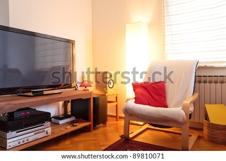 Modern living room - TV and hi-fi and chair - soft ambient light