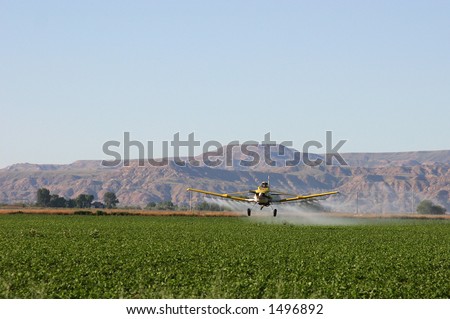 Crop duster dusting field in Wyoming valley