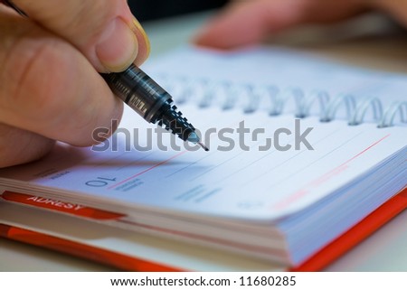 A close up of a hand of the businessman with the pen. Shallow depth of field