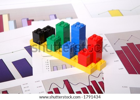 Bar chart built out of coloured toy building block on a paper chart background