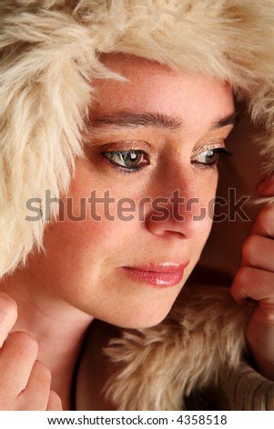 Young woman pulling her hood up to keep warm