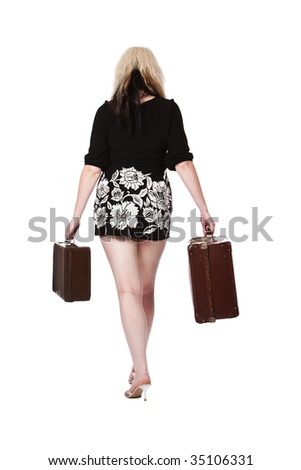 Young woman walking away from the camera holding two vintage suitcases. Isolated on a white background