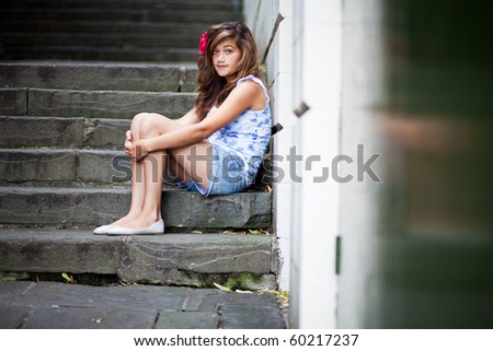 Unhappy teenager sitting on steps